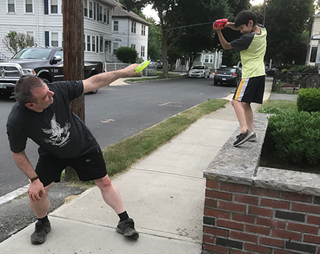 squirt gun fight with one person standing on a higher surface